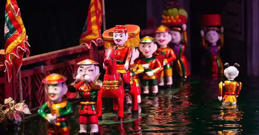 Bemalte hölzerne Wasserpuppen auf der beleuchteten Wasserbühne eines Puppentheaters in Hanoi